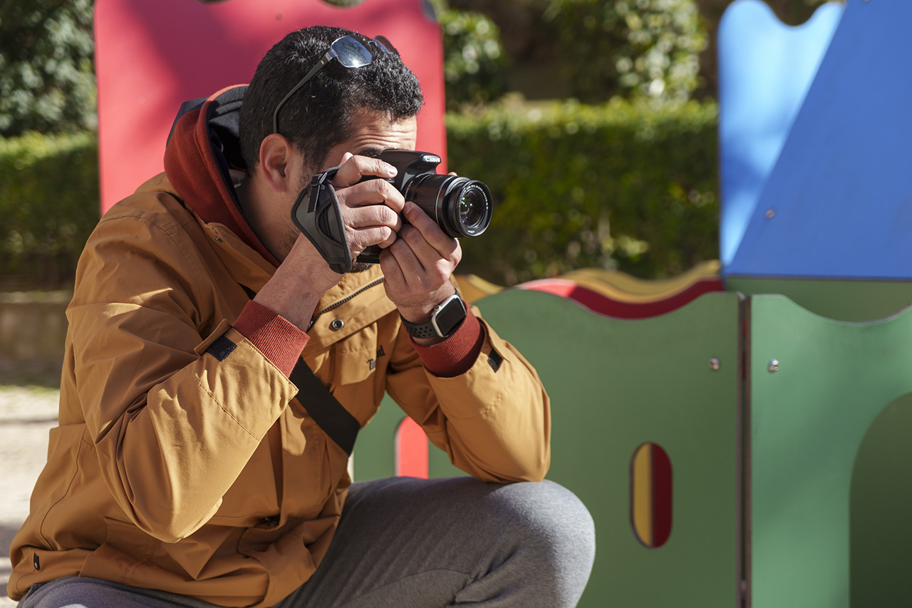 Hombre joven tomando fotografías durante un curso de fotografía de iniciación.